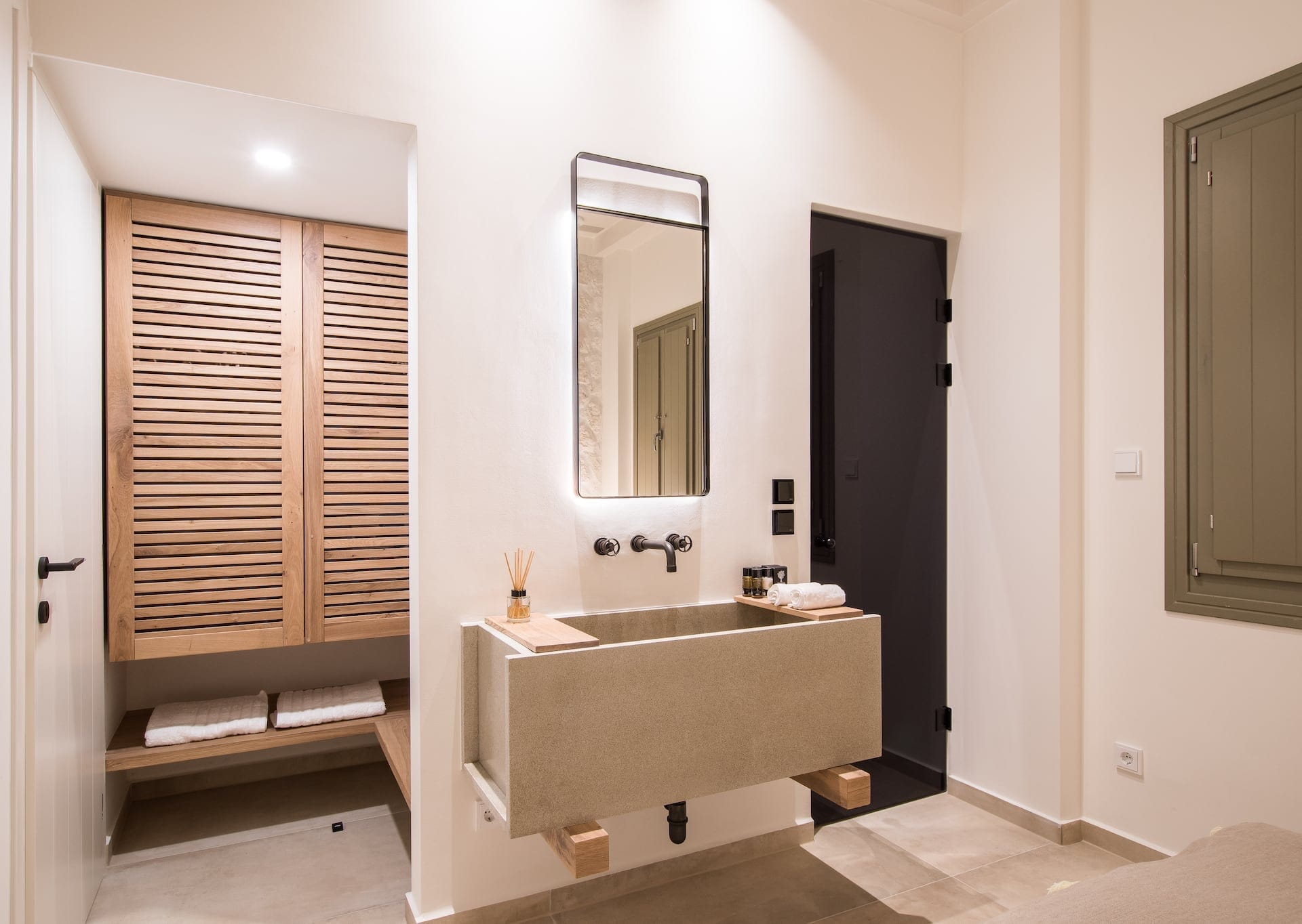 Basin on wall with a mirror inside one of the bathrooms of the luxury Pelion Beach Villas